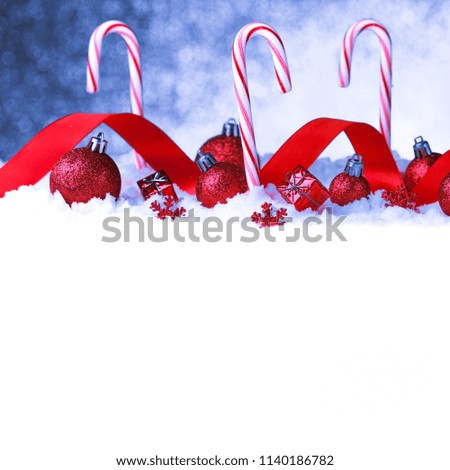 Christmas card with decorative baubles and candies on snow