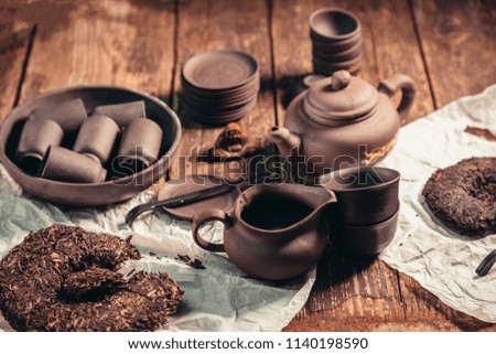 Chinese tea set and accessories made of yixing clay on an old wooden table