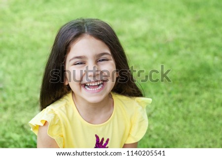 Portrait of a happy smiling child girl outdoor. Cute little girl playing in the park. 
