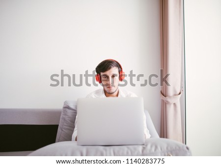 Man using laptop computer, sitting on sofa