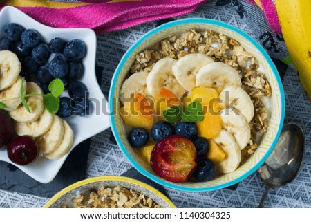 Greek natural yoghurt with granola, muesli, nectarines, blueberries, bananas and plums. Healthy breakfast idea.
