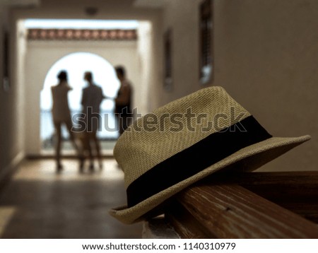 Vintage Straw hat in the foreground. People are photographed in the background.
