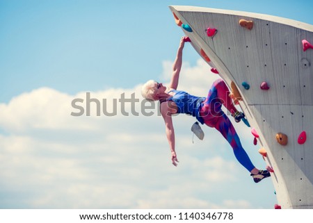 Picture from side of sports girl climbing on rocky summer day
