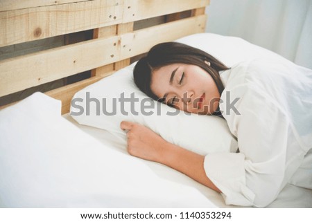 Asian Pretty young girl sleeps on bed room, portrait woman lying in bed sleeping at home late in the morning.