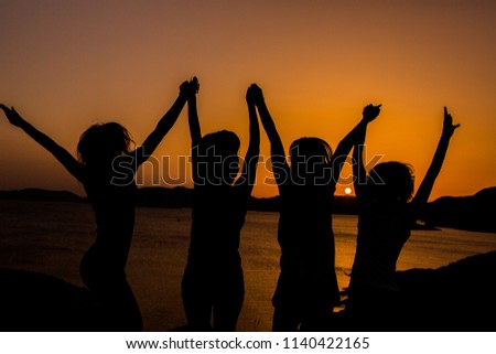 Silhouette of a happy people and sunset.