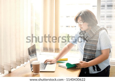 woman student using laptop in a campus open space library surfing for inspiration
