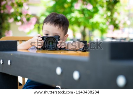 Cute little boy playing toy camera. Learning Concept. Copy space.