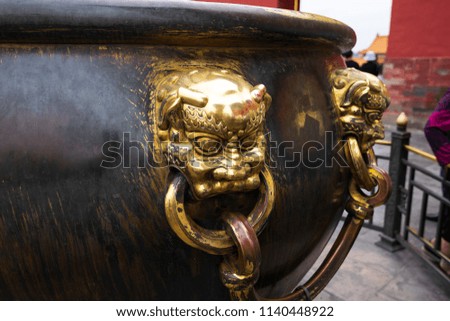 The large bronze golden bowl with the Chinese lion handle for  contain water as a protection against fire at the Forbidden City, Beijing, China