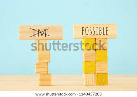 concept image of Wooden cubes that create an unstable structure and the word im next to steady one with the word possible. 
