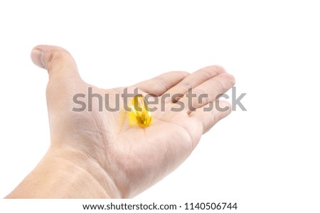 Fish oil soft gel supplement capsule source of omega and vitamins on hold hand isolated on white background