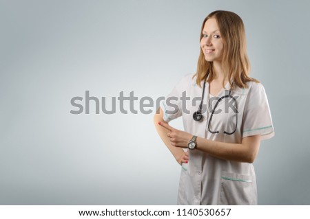 Woman doctor - on a gray background shows a finger on ...