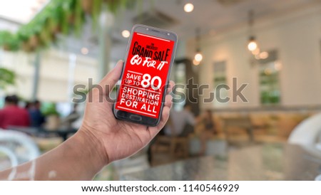 Man holding a telephone white screen -The phone holder in the left hand. Have a message to reduce the price of the product 80%