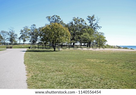Late summer at the park - taking a walk around the track. Admiring the bright blue skies and the water off the sound. Trees and bushes still green, beautiful day to relax outside.