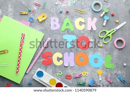 Inscription Back To School with school supplies on wooden table