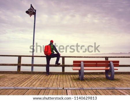 Man stand by the sea winter season.  entrepreneur enjoying evening sunset while standing outdoors in marina port.