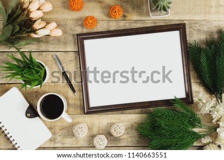 Wood picture frame, diary and coffee with flower decoration on wood background. Rustic nostalgia flat lay.