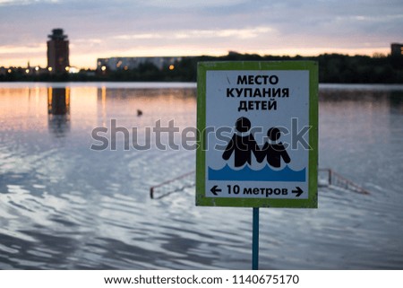A warning sign on the beach. Bathing place for children. Written in Russian: Bathing children. 10 meters away.