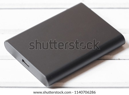 Portable Solid State Drive (SSD) on wooden board.