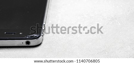 Generic broken black smartphone with a crack, isolated on white background.