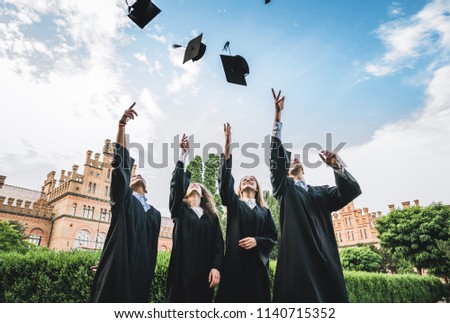 We've finally graduated!Graduates near university are throwing up hats in the air. Royalty-Free Stock Photo #1140715352