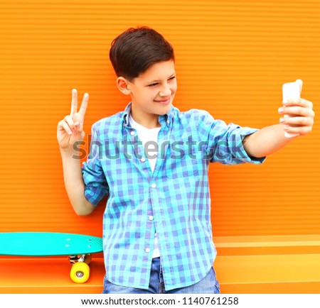 Fashion cool teenager boy is taking picture selfie on smartphone 