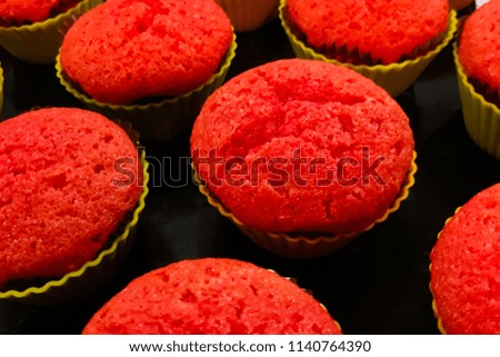 Cooking red cupcakes with filling on a black background, pattern