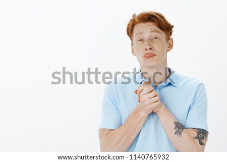 Please help me out my friend. Miserable funny european male coworker with red hair and freckles, clenching hands together over chest, pursing lips and whining, asking for favour or wanting something