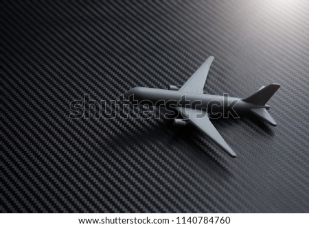 Gray Miniature toy airplane on carbon kevlar