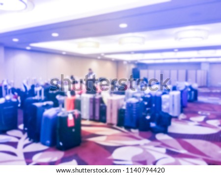 Abstract blurred luggage storage room at a luxury hotel in San Francisco, California, USA. Available for guests who want to leave bags. An unidentified employee is arranging, stack multicolor suitcase