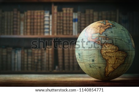 Old globe on bookshelf background. Selective focus. Retro style. Science, education, travel, vintage background. History and geography team. Royalty-Free Stock Photo #1140854771