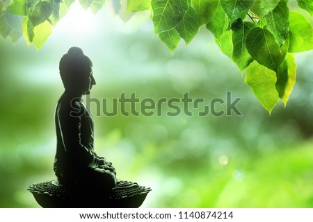 soft focus buddha statue, bodhi leaf with double exposure and len flared, dhamma concept.