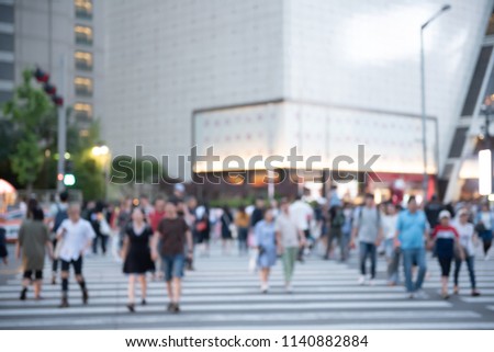 Blurred background of people crowd, travelers walking, crossing street on zebra crossing in front of department store, shopping center in the city, Seoul, Korea, urban scene