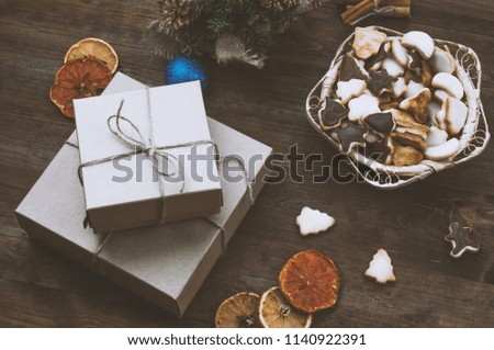 Top  view  of Christmas background. Christmas presents,cookies and dry oranges on a brown wooden table.Toned image.