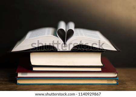 Book page in heart shape with dark background. Conceptual Heart from Book. Copy Space