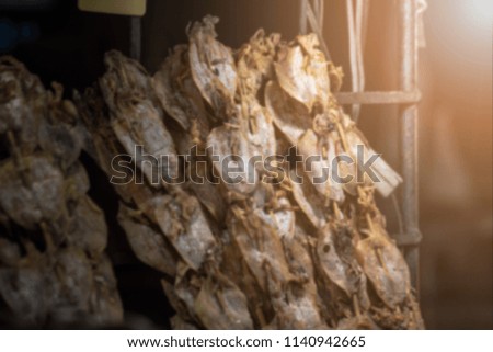 Blurred picture of dried squid at night with warm light and copy space on left of picture