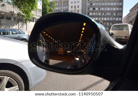 Rear view mirror with a picture of a city traffic in a city tunnel