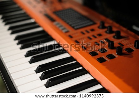Orange professional digital musical piano synthesize, Keyboard or piano for digital music recording, a music instrument background, music concept. MIDI keyboard synthesizer piano keys