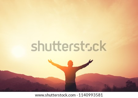 Copy space of man rise hand up on top of mountain and sunset sky abstract background. Freedom and travel adventure concept. Vintage tone filter effect color style. Royalty-Free Stock Photo #1140993581