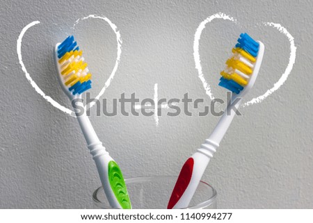 Two toothbrushes on a light background and two hearts with a plus sign. Love and Valentines Day. Copy space
