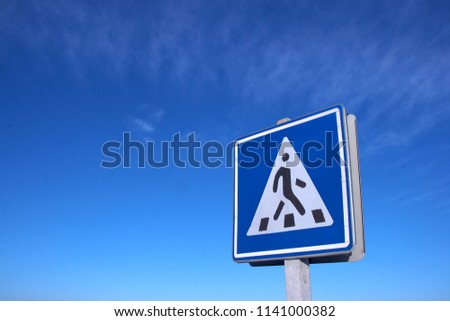 Road pedestrian crossing sign against clear deep blue sky