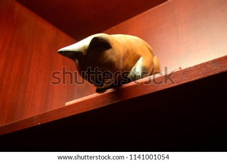 this pic show a doll cat wooden hide on the table