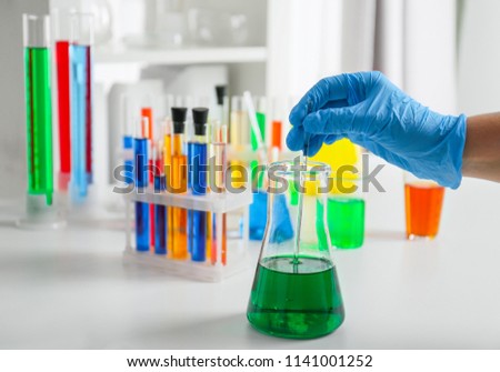 Scientist working with color liquid in laboratory