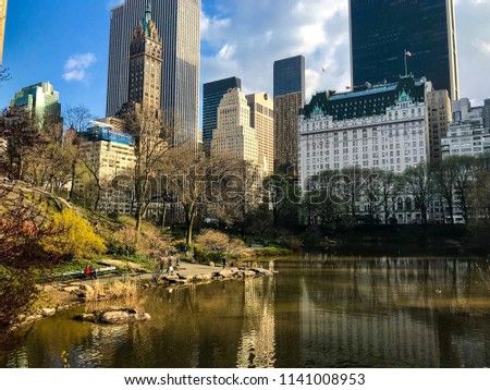 View of the Plaza Hotel and skyscrapers from the lake side in the Central Park. Cityscape, lake and trees in the Central park. Spring time in New York City.