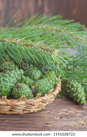 Young green pine cones in a wicker plate on a wooden table. Cones are used in folk medicine.