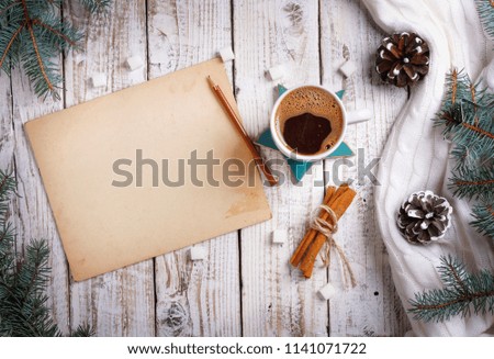 Cup of hot coffee with sugar and cinnamon and vintage sheet of paper on  old wooden table with spruce branchess. Top view flat lay group objects