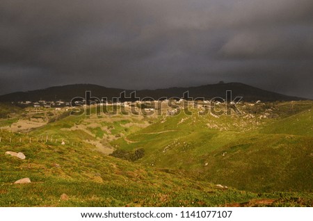 Small village located on the top of the hill and dramatic dark sky before rain.