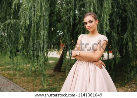 Young stylish model poses to photographer outside