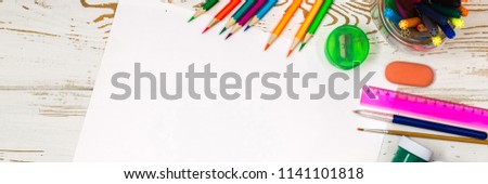 School supplies on a white wooden background with an empty space for inscriptions