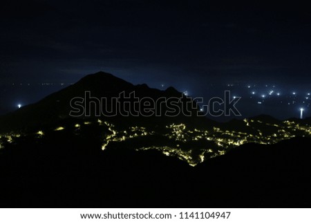road lights shine the mountain village with sparkling fishing boat lights ashore