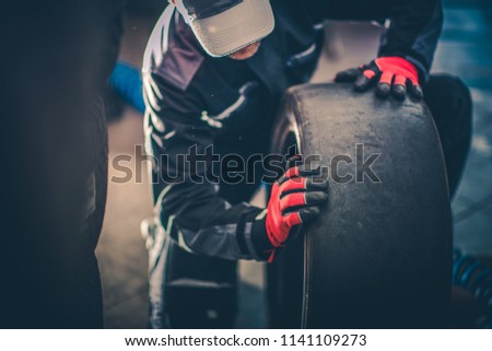 Motorsport Caucasian Worker in His 30s with Racing Slick Tire.  Royalty-Free Stock Photo #1141109273